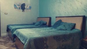 Jordanian family hosting的蓝色墙壁客房中的两张单人床