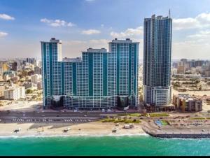 阿吉曼Ocean View Luxury Suites的享有带海滩和建筑的城市美景