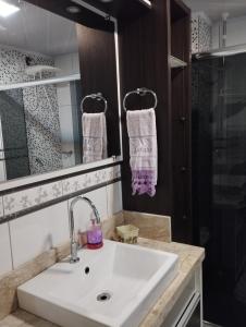南卡希亚斯Apto central completo perto de tudo的浴室配有白色水槽和淋浴。