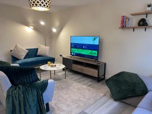 PelsallSwiftStayUK - 3-Bed fully furnished house near Wolverhampton, Walsall, Cannock - Contractors & Professional workers & Leisure的客厅配有大屏幕平面电视