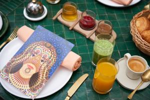 马拉喀什IZZA Marrakech的餐桌,带食物盘和橙汁杯