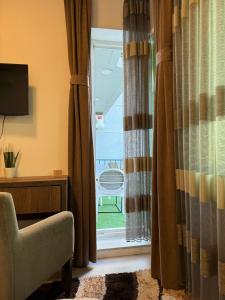 普里什蒂纳Hotel Uniluxury的客房设有带窗帘和椅子的窗户。