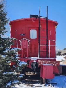 威廉姆斯大峡谷汽车旅馆和房车公园的雪中铁轨上的红色火车车