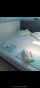 大洛希尼Hotel Heritage的一张带2条毛巾和2个枕头的白色床