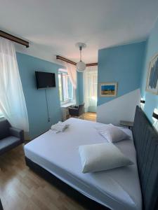 大洛希尼Hotel Heritage的一间卧室配有一张白色大床和蓝色的墙壁