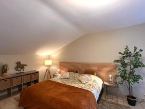 EllezellesAu Coeur Des Collines, Chouette的一间卧室配有一张大床和木制床头板