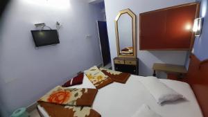 穆扎夫法尔普尔Hotel swapanlok, Couple Friendly Hotel的卧室配有一张床,墙上配有电视。