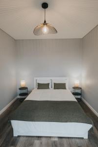 卡马拉-德洛布什Pico Apartment's的卧室配有白色的床和两盏灯。
