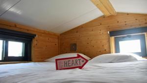 EstevaisTiny house eco resort的木墙间床上的心枕
