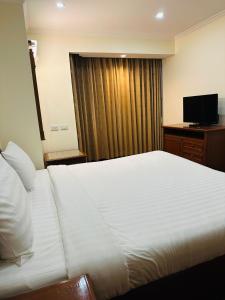 曼谷Omni Tower Sukhumvit Nana by Direct Rooms的酒店客房,配有床和电视