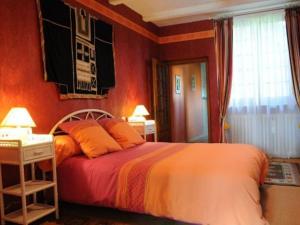 FuteauGuestroom Futeau, 1 pièce, 2 personnes - FR-1-585-106的一间卧室配有橙色墙壁的床