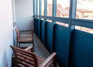 布拉格The Hotel Fitzgerald的两把椅子坐在阳台,阳台设有两扇窗户