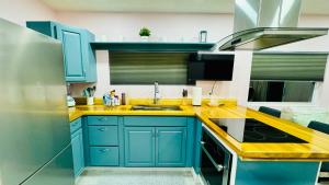 萨拉索塔Sunrise Tiny Home - New&Cozy的厨房配有蓝色橱柜和黄色台面