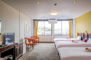 Miki双龍居ホテル的酒店客房设有四张床和电视。