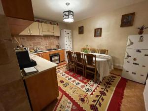 瓦马Casa cu Pitici的厨房配有桌椅和冰箱。