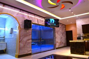 雷伊斯منتجع شاطئ العرب - خليج الرايس的带淋浴的浴室以及墙上的电视。