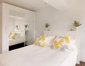 希洪Playa de San Lorenzo的卧室配有白色床和黄色及白色枕头