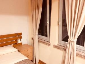 MontechiarugoloPrivate Room close to Beautiful Parma的一间卧室设有一张床和两个窗户。