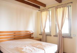 MontechiarugoloPrivate Room close to Beautiful Parma的一间卧室设有一张床和两个窗户。
