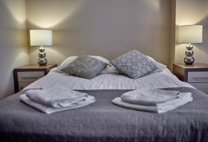 苏瓦乌基Apartamenty-Europejska的床上配有毛巾和枕头