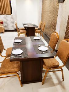 戈勒克布尔HOTEL JVS PALACE的一间带2张桌子和椅子的用餐室