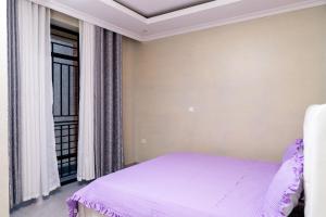 基加利Kigali Homes Villa的一间卧室设有一张床和一个窗口