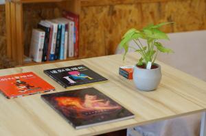 恒春古城Back to spring BnB的一张桌子,上面有两本书和一株盆栽植物
