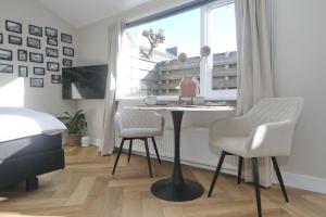 海滨诺德韦克Huisje bij Zee (gratis parkeren)的客房设有桌子、两把椅子和窗户。