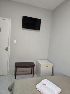 圣若昂达博阿维斯塔Hotel Bandeirantes de SJBV的卧室配有一张床,墙上配有电视。