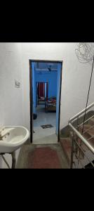 德奥加尔MAA MANSHA GUEST HOUSE的一间带水槽的浴室和一扇通往客房的门