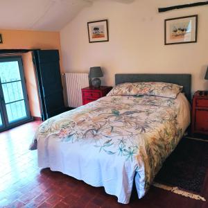 尼翁Le Ptit Cottage的一间卧室配有一张带花卉床罩的床
