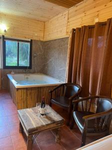 בוסתן החורש- חיפה的带浴缸、两把椅子和一张桌子的房间