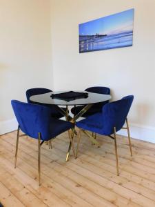 格拉斯哥Beautiful & spacious 2 bed apt in Glasgow West End的一张桌子和四把蓝色椅子