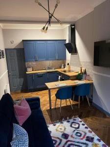 格拉斯哥Stunning 1 bed Apt in West End的厨房配有蓝色橱柜和桌椅