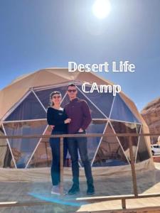 瓦迪拉姆Desert Life Camp的站在帐篷前的男女