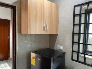 阿克拉Arm Beach Lodge的厨房配有黑色冰箱和木制橱柜。