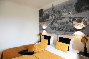 赫拉尔兹贝亨库鲁帕罗酒店的卧室配有一张床,墙上挂有绘画作品