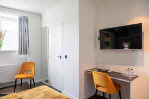 赫拉尔兹贝亨库鲁帕罗酒店的客房设有书桌和墙上的电视