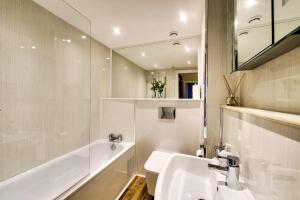 格拉斯哥Stylish & Spacious 3 Bedroom Apt in Finnieston, West End的白色的浴室设有水槽、浴缸和镜子