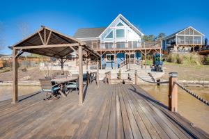 New LondonLakefront New London Retreat with Dock and Hot Tub!的房屋设有木甲板,配有桌椅