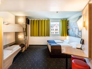莱茵河畔威尔B&B Hotel Weil am Rhein/Basel的客房设有两张双层床和一扇窗户。