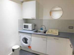 格拉斯哥2 Bedroom Apt in the Heart of the City Centre, perfect Location的厨房配有洗衣机和微波炉。