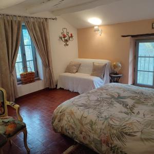 尼翁Le Ptit Cottage的一间卧室设有一张床和两个窗户。