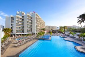 美洲海滩Alexandre Hotel Troya的一个带椅子的度假游泳池和一间酒店