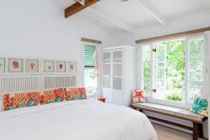 别霍港Hotel Aguas Claras Member of the Cayuga Collection的白色的卧室设有床和窗户
