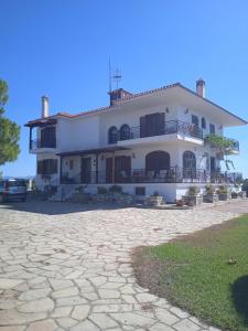 尼坡帝Olive tree 5 bedroom VIlla in Potidaia, Kassandra Chalkidiki的一座带石头车道的大型白色房屋