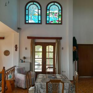 尼坡帝Olive tree 5 bedroom VIlla in Potidaia, Kassandra Chalkidiki的客厅配有桌子和2个彩色玻璃窗