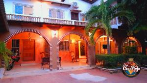San LorenzoCasa Vieja Hotel y Restaurante的一座橙色的建筑,有拱门和棕榈树