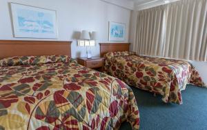 大洋城Fish Tales Boardwalk Inn & Ocean Mecca Motel的酒店客房设有两张床和窗户。