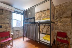卡米尼亚Albergue Santiago de Caminha的石墙内带双层床的房间